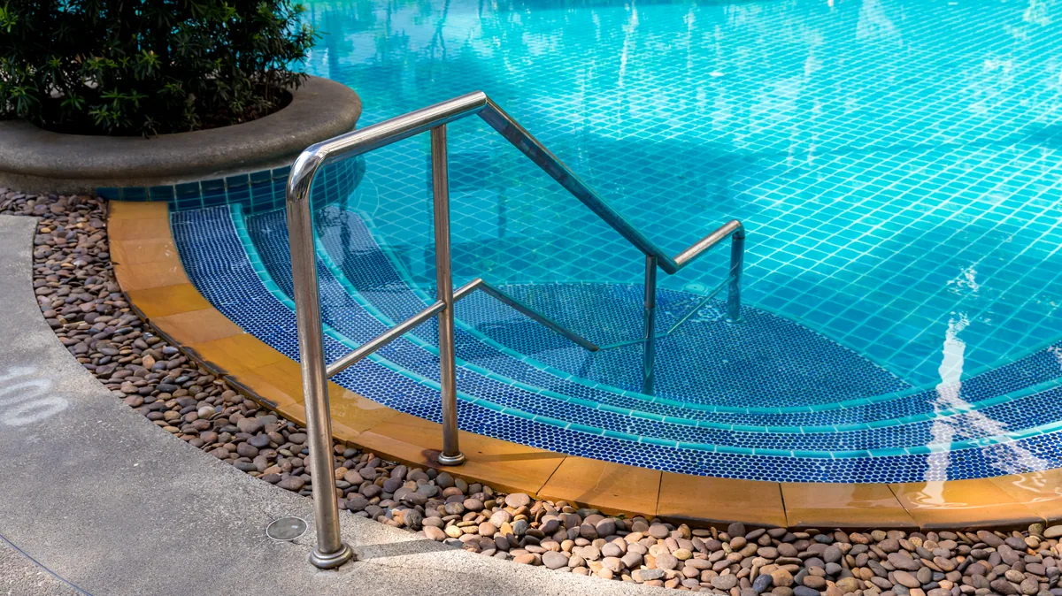 Corrimão de inox na entrada de piscina com pastilha azul