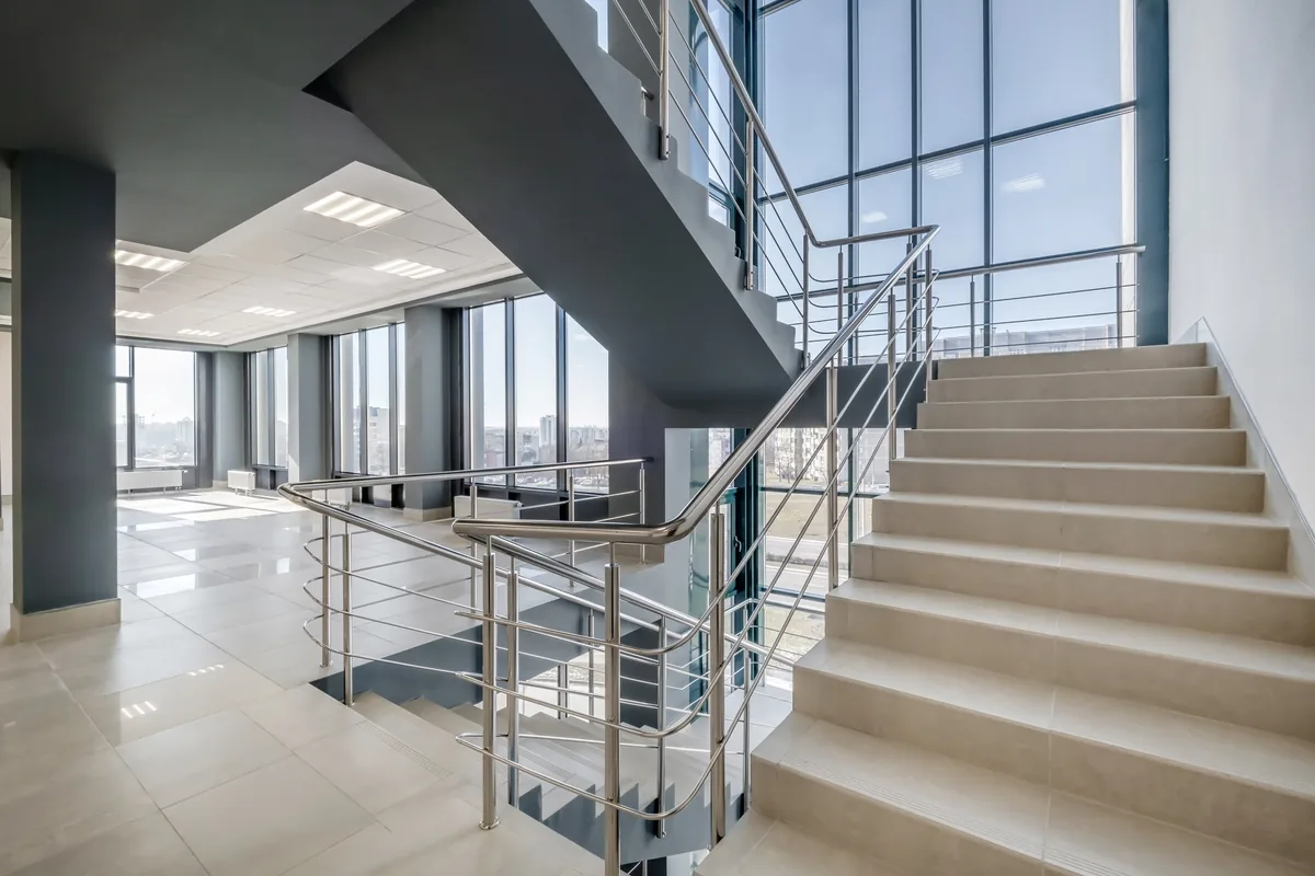 Escada moderna com guarda-corpo de inox em edifício corporativo com fachada de vidro