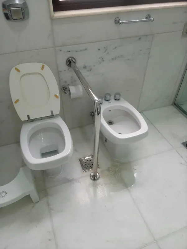Barras de apoio de inox em banheiro acessível conforme NBR 9050