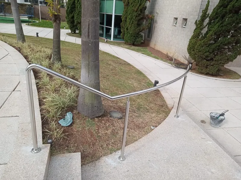 Corrimão de aço inox curvo em caminho de jardim