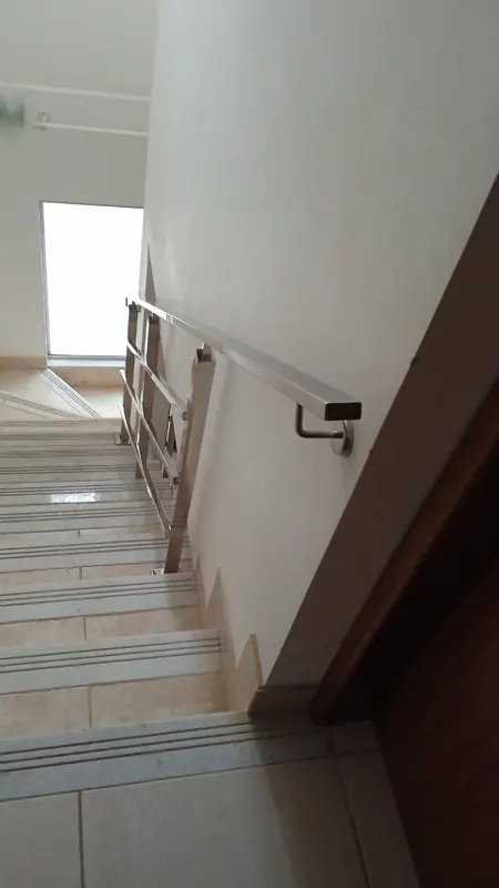 Corrimão de inox fixado na parede em escada interna