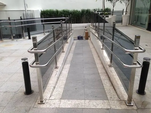 Corrimão de inox em rampa de acessibilidade em área comum