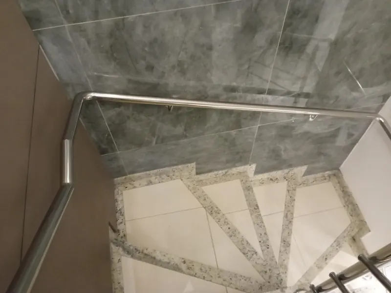 Corrimão de parede em inox acompanhando escada em curva