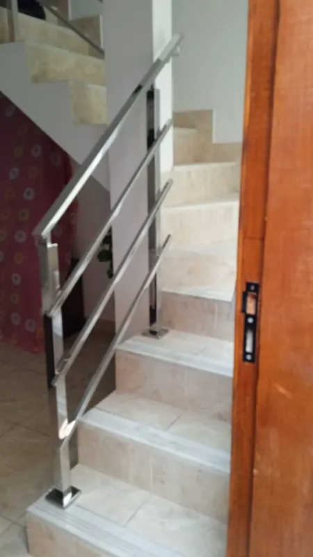 Guarda-corpo de inox em escada interna com degraus claros