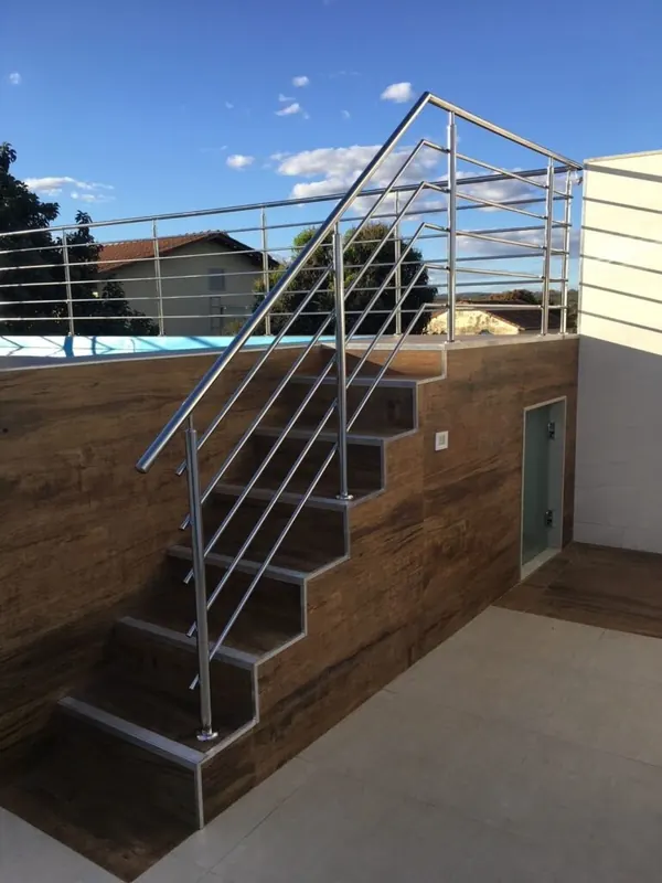 Guarda-corpo de inox com travessas em escada externa ao lado da piscina