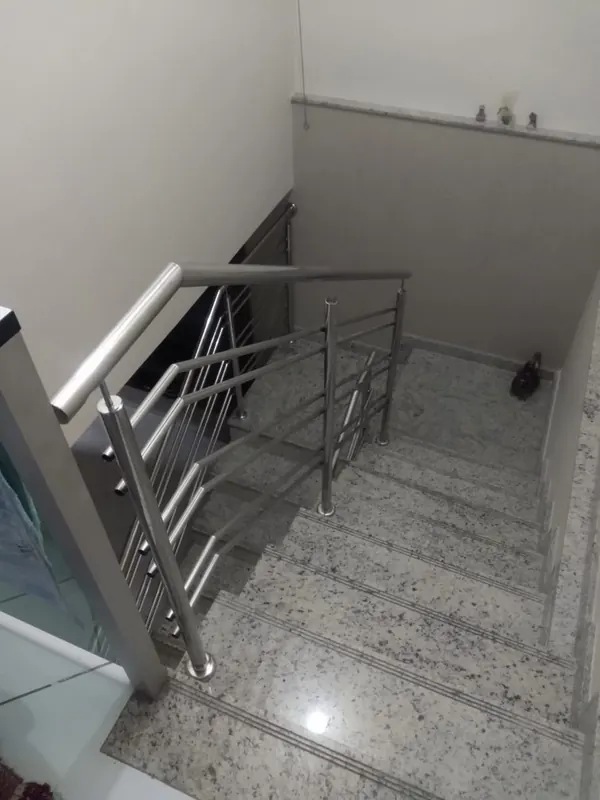Guarda-corpo de inox em escada interna com degraus de granito