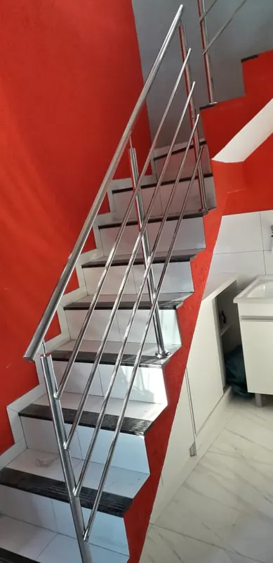 Guarda-corpo de inox em escada com parede vermelha