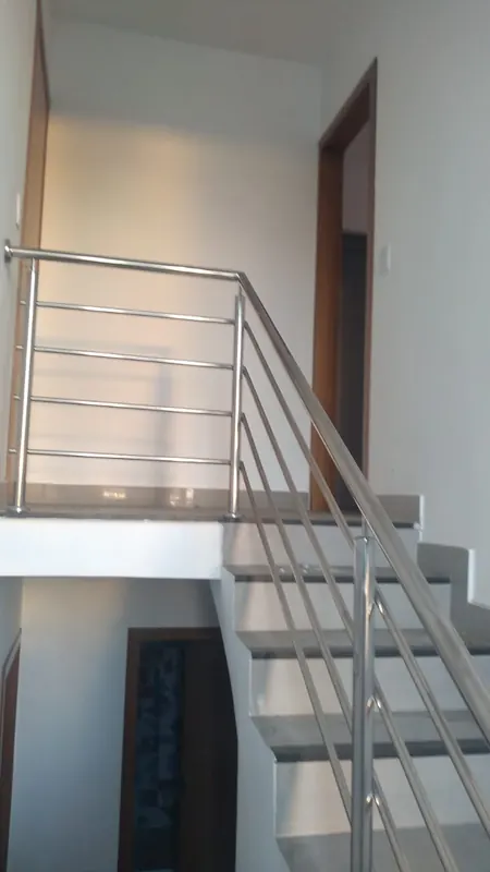 Guarda-corpo de inox protegendo vão de escada interna